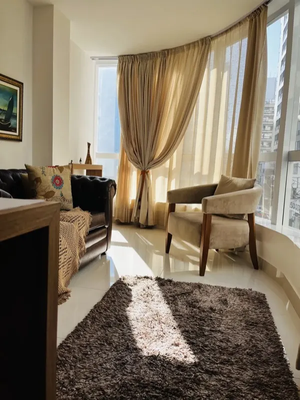 Sala de atendimento com sofá de couro e janela curva